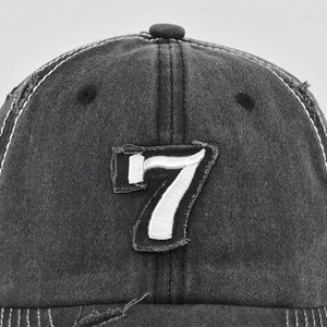 Close-up of vintage washed grey baseball cap featuring a distressed number 7 patch