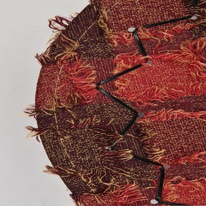 Close-up of ethnic woven pattern on cowboy hat with crimson gold silk and long tassels