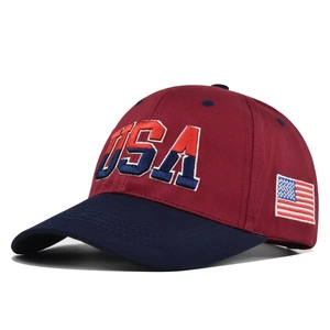 Detailed close-up of 3D USA embroidery and American flag patch on red and blue baseball cap