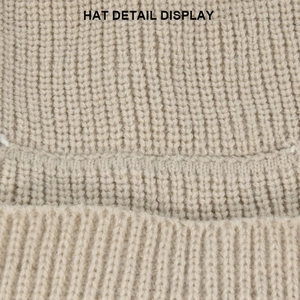 Vista macro del cappello beige in maglia grossa che mostra la trama spessa a coste