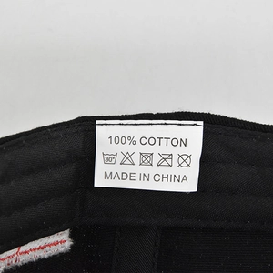 Detail showing the 100% cotton material label and care instructions for the baseball cap