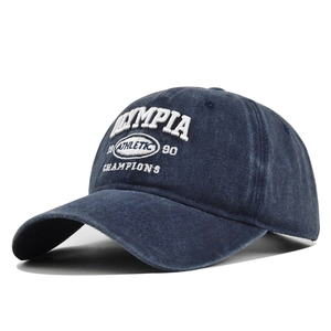 Nahaufnahme der Retro Olympia 1990 Stickerei auf der marineblauen Baumwollkappe