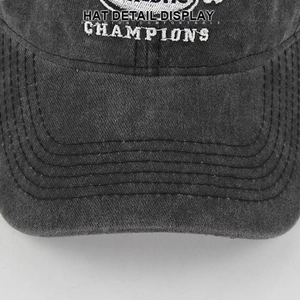 Detail der Baseballkappe aus gewaschener Baumwolle mit Champions Stickerei und Vintage Naht