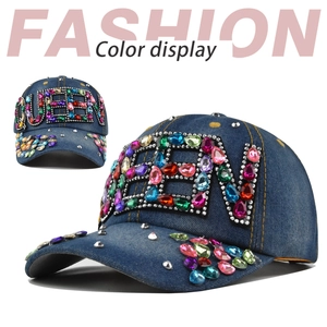 Detail of blue denim baseball cap with QUEEN rhinestone letters and colorful stud accents