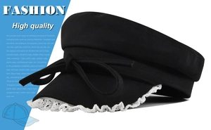 Detail view of black sailor hat with white lace trim and bow knot on the brim