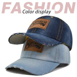 Detail of distressed denim baseball caps with vintage leather patches in blue and light blue