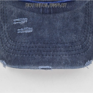 Détail du bord de casquette en jean bleu usé avec finitions vintage effilochées et coutures