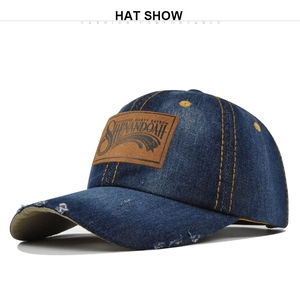 Detail of distressed denim baseball cap with leather logo patch and yellow contrast stitching