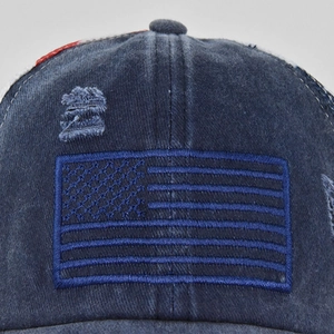 Détail du drapeau américain brodé et de la texture denim vieilli sur la casquette bleu