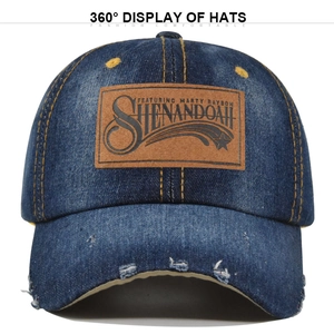 Detail of distressed denim baseball cap with brown leather patch and vintage torn brim