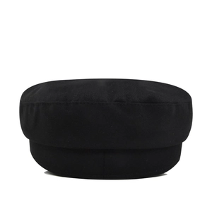 Detail view of the flat top structure and stitching of the black baker boy cap