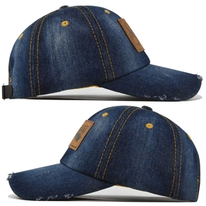 Close-up of distressed denim baseball cap with leather logo and yellow contrast stitching