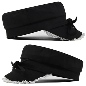 Detail of black flat top cap featuring white lace trim and a side ribbon bow accent