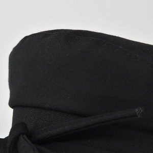 Close-up of black cotton twill fabric texture and stitching on the newsboy hat