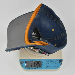 Detailed weight measurement of 119.9g for rhinestone denim baseball cap on scale