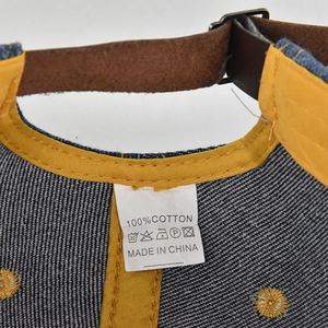 Macro view of distressed denim cap showing interior yellow seams and leather strap