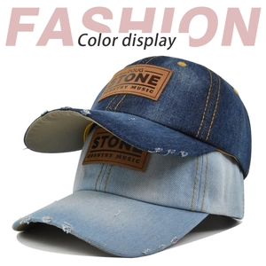 Detail of distressed denim baseball caps with frayed holes and brown leather patch branding