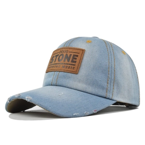 Vintage light blue washed denim baseball cap with distressed holes and leather patch