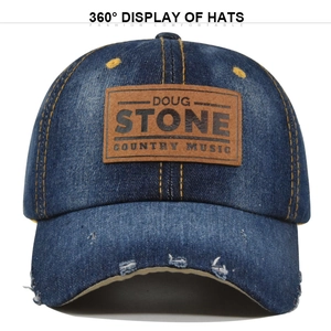 Detail of distressed navy denim baseball cap with brown leather Doug Stone logo patch