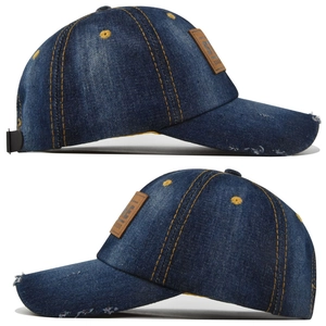 Close-up of distressed denim baseball cap with yellow stitching and leather patch