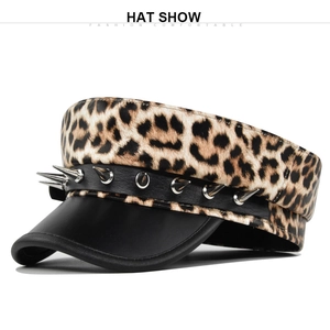 Detail view of leopard print beret with silver metallic rivets and black leather strap