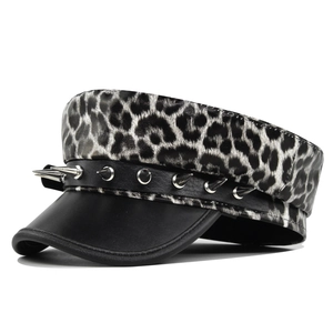 Detail of leopard print military cap with black leather strap and silver metal spikes