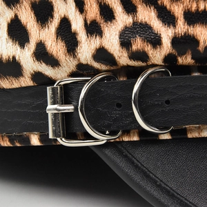 Close-up of leopard print beret with black leather strap and silver metal buckle details