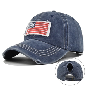 Close-up of distressed denim ponytail baseball cap with embroidered USA flag patch