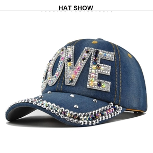 Dettaglio del logo LOVE in strass e trama denim su un berretto blu scuro