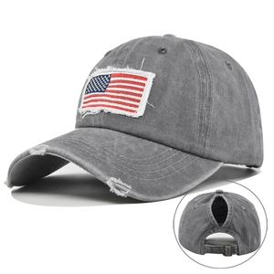 Close-up of distressed grey ponytail baseball cap featuring American flag embroidery