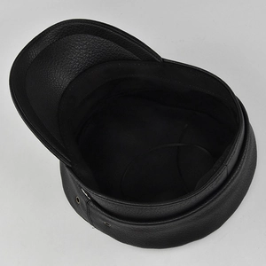 Detailed macro view of black PU leather baker boy hat with inner lining and metal eyelets