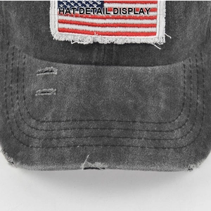 Macro shot of embroidered US flag on vintage grey ponytail baseball cap with distressed brim