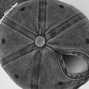 Detail of distressed charcoal cotton baseball cap with ponytail hole and vintage worn edges