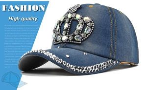 Detailed close-up of crown rhinestone patterns on navy blue denim baseball cap