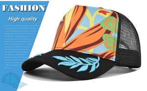 Detail view of tropical floral embroidery and blue leaf stitching on the black hat brim