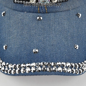 Detailed close-up of rhinestones on blue denim fabric of the stylish baseball cap