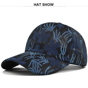 Detalle de gorra de béisbol negra con bordado de encaje floral azul y textura de malla