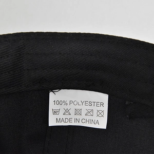 Macro view of a black baseball cap inner label showing 100% polyester fabric details