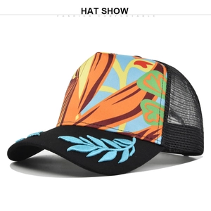 Detail of tropical floral print trucker hat with blue leaf embroidery on black brim
