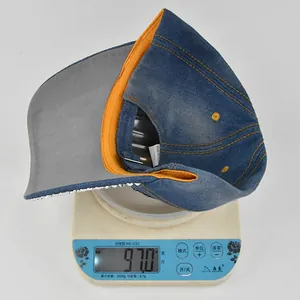 Close-up of blue washed denim rhinestone baseball cap on scale showing weight of 97.0g