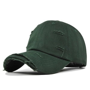 Gros plan détaillé sur les effets de trous usés sur la visière de la casquette verte