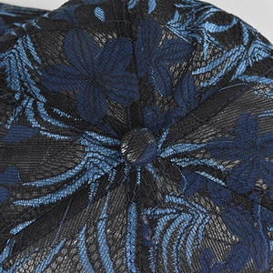Detalle macro del bordado floral de encaje azul transpirable en la parte superior de la gorra