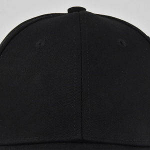 Close-up of black cotton twill baseball cap with reinforced seams and embroidered eyelets