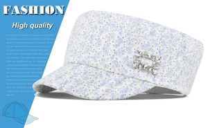 Detail view of a light blue floral cadet cap with a sparkling rhinestone buckle decoration