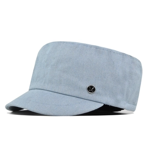 Lichtblauwe gewassen denim flat top legerpet met een metalen M-badge op wit canvas