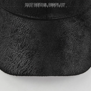 Detail showing the distressed crackle texture of a black suede baseball cap with a curved brim