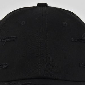 Détail de l'effet vieilli avec trous et œillets d'aération sur une casquette de baseball noire
