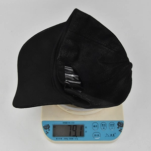 Detail showing the lightweight 79.1g suede baseball cap on a digital weighing scale
