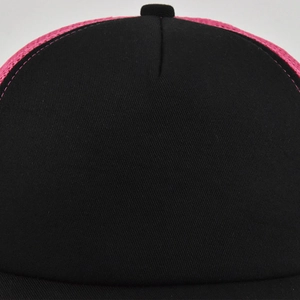 Close-up of black fabric and rose pink mesh texture on a stylish trucker baseball cap