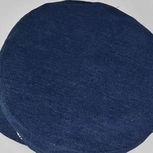 Detailopname van de donkerblauwe denimtextuur en de zilveren metalen klinknagel op de platte pet